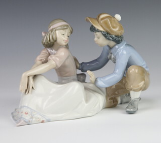 A Lladro figure of a seated boy and girl 5454 15cm together with a Nao figure of a girl holding a puppy 18cm and ditto of a girl 22cm 