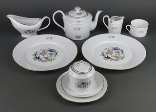 A Limoges dinner service with exotic birds and gilt rims, monogrammed SK, comprising 12 coffee cans, 12 saucers, 12 small plates, 11 medium plates, 24 dinner plates, 12 soup bowls, 12 dessert bowls, a sauce boat, a teapot, milk jug, sugar bowl, tureen and cover, oval meat plate, deep bowl 
