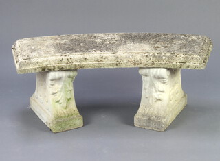 A well weathered crescent shaped concrete garden bench, raised on scrolled supports 44cm h x 113cm w x 37cm d 