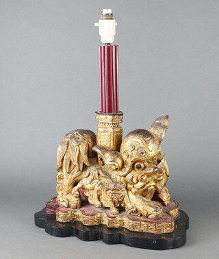 A Chinese carved and pierced hardwood table lamp in the form of a Shi Shi 44cm h x 37cm w x 17cm d 