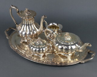 A silver plated 2 handled tray with engraved decoration and a 4 piece plated tea and coffee set 