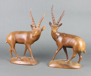 Two African carved hardwood figures of standing gazelles raised on oval bases 30cm h x 16cm w x 9cm 