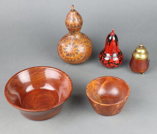 A turned wooden pot with gilt lid, raised on 3 bun supports 9cm x 4cm, a Russian black and red lacquered trinket box in the form of a pear 13cm x 5cm, a carved gourd 19cm x 9cm, 2 turned wooden bowls 7cm x 18cm and 6cm x 11cm 