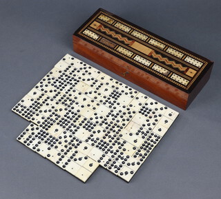 A 19th Century rectangular inlaid mahogany cribbage board with hinged lid 5cm x 28cm x 10cm (missing sections of veneer to the top) containing 55 bone and ebony dominoes together with 5 bone markers, 3 plastic dice and other markers 