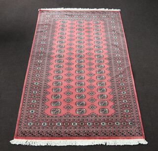 A pink, green and white ground Bokhara rug with 55 octagons to the centre 255cm x 158cm 