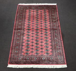 A pink and white ground Bokhara carpet with 54 octagons to the centre 246cm x 158cm 