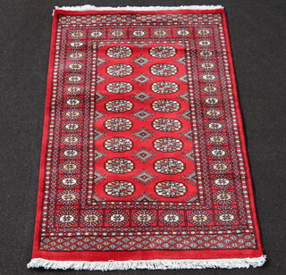 A red and white ground Bokhara rug with 16 octagons to the centre 152cm x 91cm 