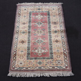 A Turkish Caucasian style pale yellow and green ground rug with 4 diamonds to the centre 190cm x 119cm 