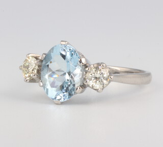 A white metal stamped Plat aquamarine and diamond ring, the centre oval stone 2ct, the 2 brilliant cut diamonds 0.55ct, size O, 5.9 grams 