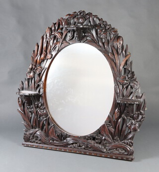 A Victorian oval plate over mantel mirror contained in a carved and pierced mahogany frame, carved iris, fitted 3 shelves 135cm h x 133cm w x 20cm d 