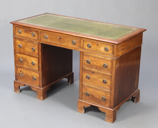 A walnut kneehole pedestal desk with green inset writing surface above 1 long and 8 short drawers, raised on bracket feet 74cm h x 118cm w x 56cm d 
