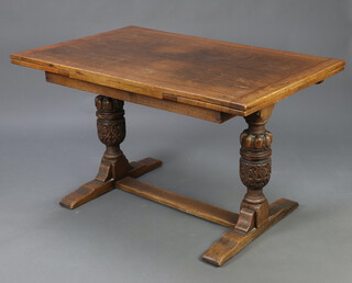 An oak drawleaf dining table raised on cup and cover supports with H framed stretcher 76cm h x 129cm x 82cm 