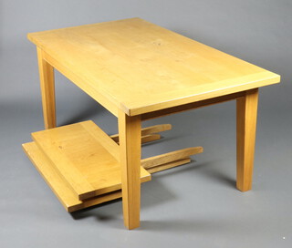 A rectangular light oak dining table with 2 extensions, raised on square supports 77cm h x 167cm l x 91cm w 