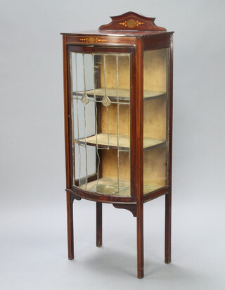 An Edwardian Art Nouveau simulated inlaid mahogany bow front display cabinet with lead glazed panelled doors, raised on square tapered supports 148cm h x 58cm w x 36cm d (top is scratched, warped, water marked and the lead glazed panel to the front is damaged)