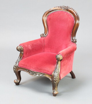 A childs size Victorian style carved show frame chair upholstered in red material 53cm h x 39cm w x 34cm d 
