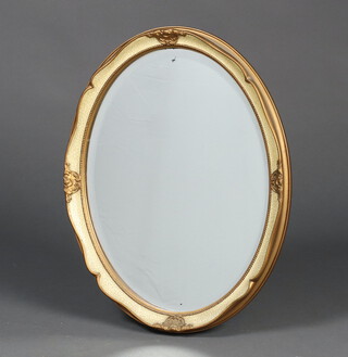 An oval bevelled plate wall mirror contained in a gilt and cream frame 45cm x 35cm 