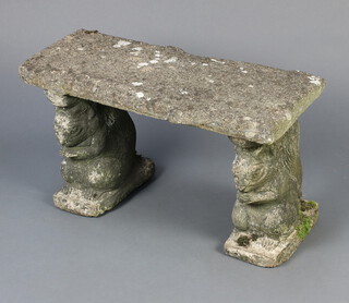 A well weathered rectangular concrete garden bench supported by squirrel supports 37cm h x 65cm w x 31cm d 
