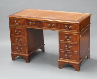 A mahogany kneehole pedestal desk with brown inset writing surface above 1 long and 8 short drawers, raised on bracket feet 78cm h x 121cm w x 61cm d (sun bleached throughout, leather rising) 