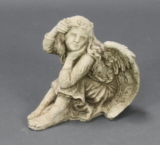 A composition figure of a seated angel 25cm h x 31cm x 19cm 