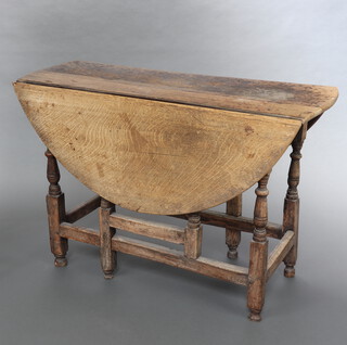 An 18th Century bleached oak gateleg dining table fitted a frieze drawer, raised on turned supports 72cm h x 108cm w x 40cm when closed x 107cm when open (both rule joints are loose, split and water marks to the top)
