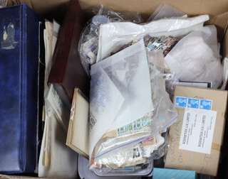 A collection of American and world used stamps, some on paper, contained in a cardboard box 