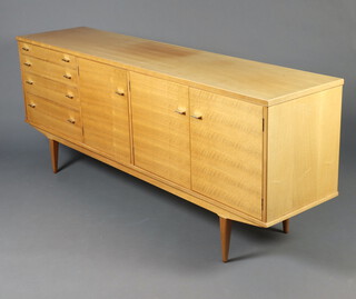 A mid-Century Jaycee crossbanded and bleached walnut sideboard, fitted 4 long drawers and 3 cupboards, raised on square tapered supports 80cm h x 199cm w x 46cm d (sun bleached and with light scratches in places) 