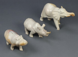 A carved stone figure of a walking elephant 20cm h x 30cm x 13cm, ditto rhinoceros 13cm x 30cm x 14cm and a hippopotamus 13cm x 31cm x 13cm 