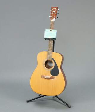 A Yamaha F-310 guitar, together with a guitar and bass tuner and guitar stand 