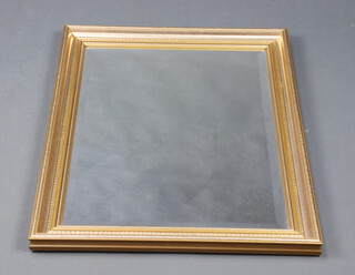 A rectangular plate mirror contained in a decorative gilt frame 73cm x 56cm w 