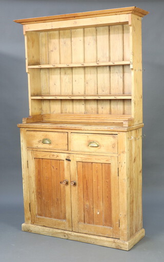 A pine dresser, the raised back with moulded cornice fitted 2 shelves, the base fitted 2 drawers above double cupboard, raised on a platform base 191cm h x 106cm w x 36cm d (stains in places) 