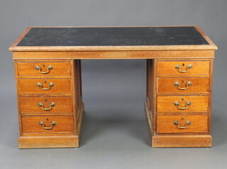 An oak desk of 8 short drawers with brass swan neck drop handles and inset writing surface 75cm h x 143cm w x 76cm d (some pitting to the writing surface)