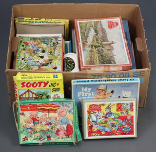 A box containing a collection of children's jigsaw puzzles 