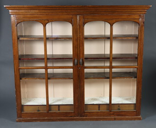 A Victorian pine bookcase/display cabinet with moulded cornice, fitted adjustable shelves enclosed by pair of arch panelled doors, the base fitted 3 drawers 151cm h x 170cm w x 40cm d (section of cornice is missing) 