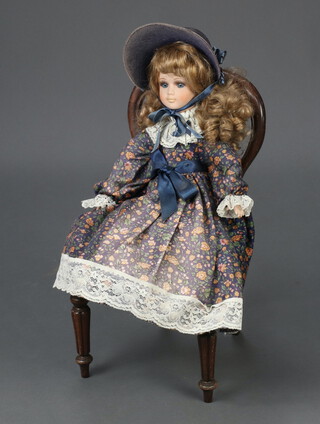 A Victorian style child's balloon back chair with carved mid rail and upholstered seat, raised on turned supports 45cm x 23cm x 22cm together with a reproduction Victorian style costume doll 