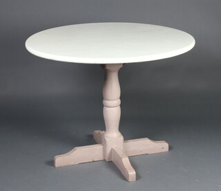A circular white painted pine pedestal dining table raised on turned supports with cruciform base 72cm h x 95cm diam. 
