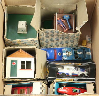 Three Triang Scalextric racing cars contained in 2 boxes, 3 Scalextric buildings, F/3-2 TV camera and crew set, First Aid hut and control tower, all part boxed, a Scalextric car boxed and various figures 