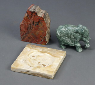 A carved section of polished hardstone 18cm x 14cm x 7cm, a carved green hardstone figure of a standing elephant 12cm x 16cm x 7cm and a white marble ashtray 3cm x 20cm x 20cm 