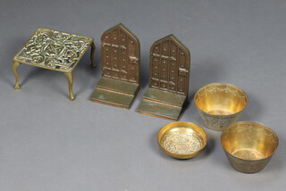 A pair of heavy brass bookends in the form of doors 17cm x 9cm x 8cm, pierced brass trivet decorated a Royal Coat of Arms 9cm x 14cm x 15cm, a pair of benares brass bowls 7cm x 12cm, a brass dish decorated Tudor rose 3cm x 10cm 