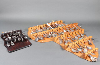 A collection of silver plated souvenir spoons in 2 racks 