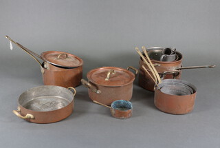 A collection of copper saucepans contained in a twin handled wicker basket 
