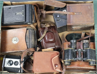 A butcher's reflex carbine camera, 3 folding cameras, 2 other cameras and a pair of military issue binoculars 