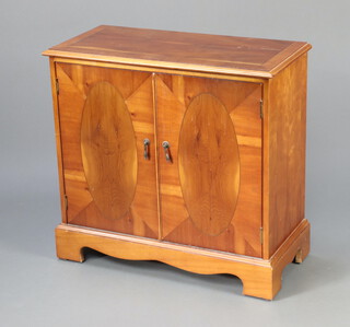 A Georgian style crossbanded yew cabinet enclosed by panelled doors, raised on bracket feet 71cm h x 75cm w x 35cm d 