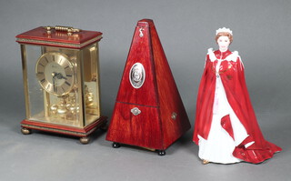 A Royal Worcester figure in celebration of The Queen's 80th Birthday 2006, a quartz 400 day clock and a metronome boxed 