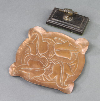A Victorian iron and brass paperweight in the form of a clenched hand folding a rod 5cm x 9cm x 5cm together with a Newlyn style embossed copper tray 15cm x 15cm 