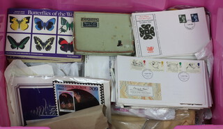 A collection of GB and World used stamps on paper, first day covers etc, contained in a pink plastic crate  