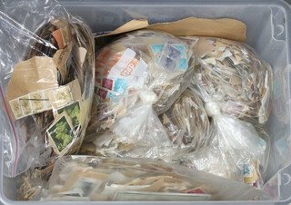 A quantity of GB stamps on paper in a plastic box 