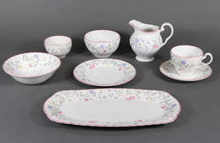 A Johnson Bros. part tea service decorated with spring flowers comprising 9 tea cups, 9 saucers, 8 small plates, 2 serving plates, 3 bowls and a milk jug together with 4 dessert bowls 