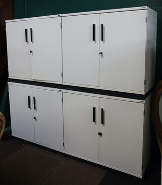 A suite of Kinnarps white finished storage units comprising 4 white laminate cabinets enclosed by panelled doors 72cm h x 80cm w x 42cm d together with 1 with sliding door to the side 124cm h x 80cm w x 43cm d  