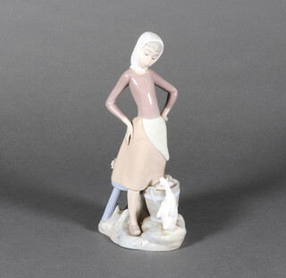 A Lladro figure of a goose girl, the goose beside a pail 24cm 