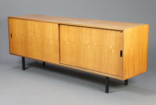 A mid-Century teak sideboard, the interior fitted 3 trays enclosed by sliding panelled doors, raised on square metal supports 70cm h x 183cm w x 46cm d (some sun bleaching and water marks) 